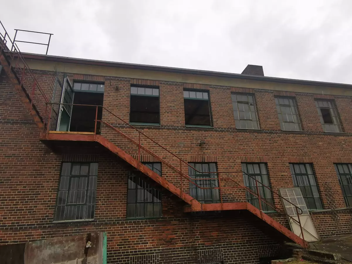 Historische Backsteinfassade der ehemaligen Vulkanfiberfabrik mit außenliegender Stahltreppe